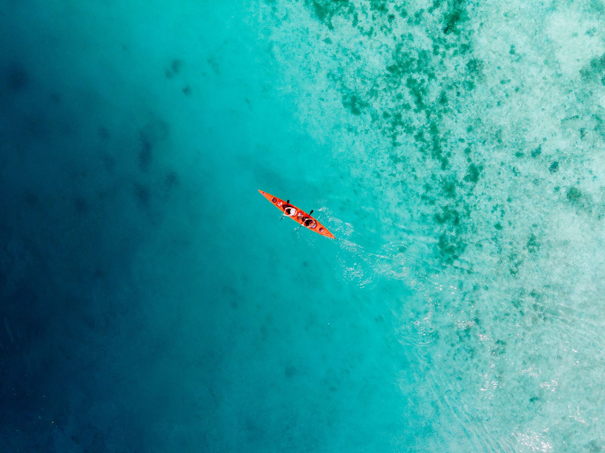 Pemandangan udara kayak dikelilingi laut biru kehijauan di Indonesia.  Foto: Petualangan Jahat