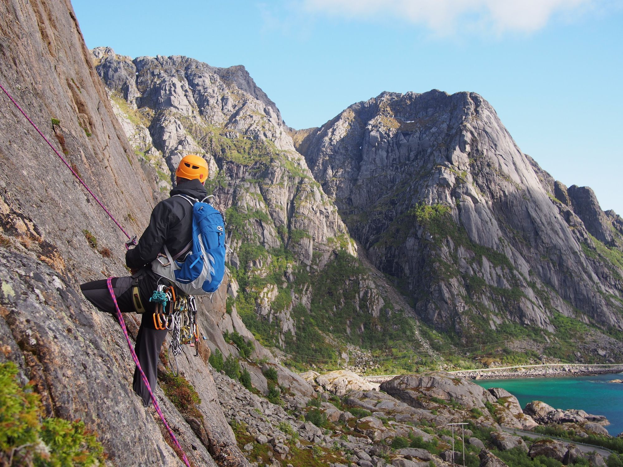 A rock climber gets ready to scale a granite cliff on the Lofoten Islands, Norway.