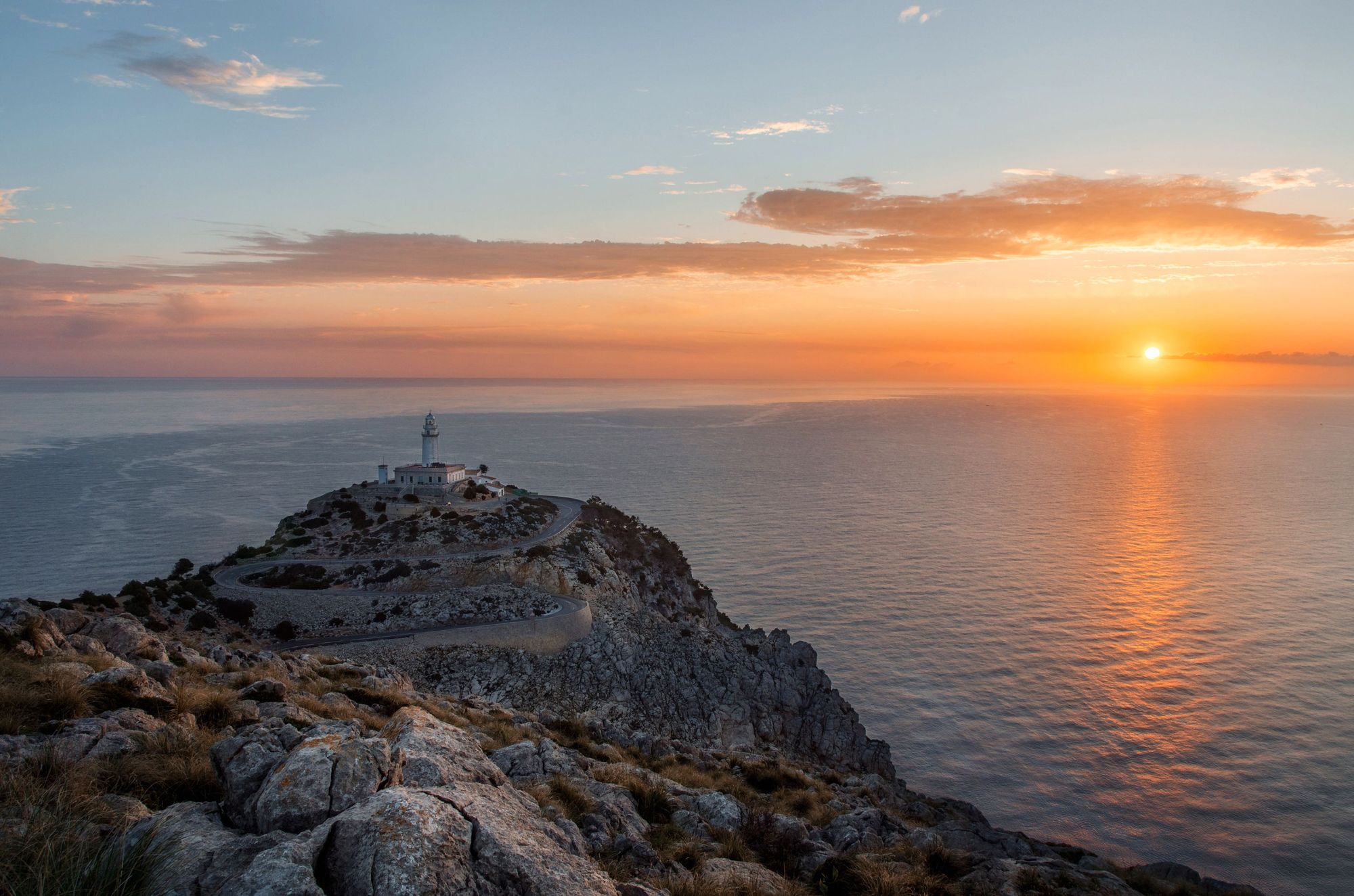 The Formentor lighthouse, in front of the setting sun in Mallorca. Photo: Getty