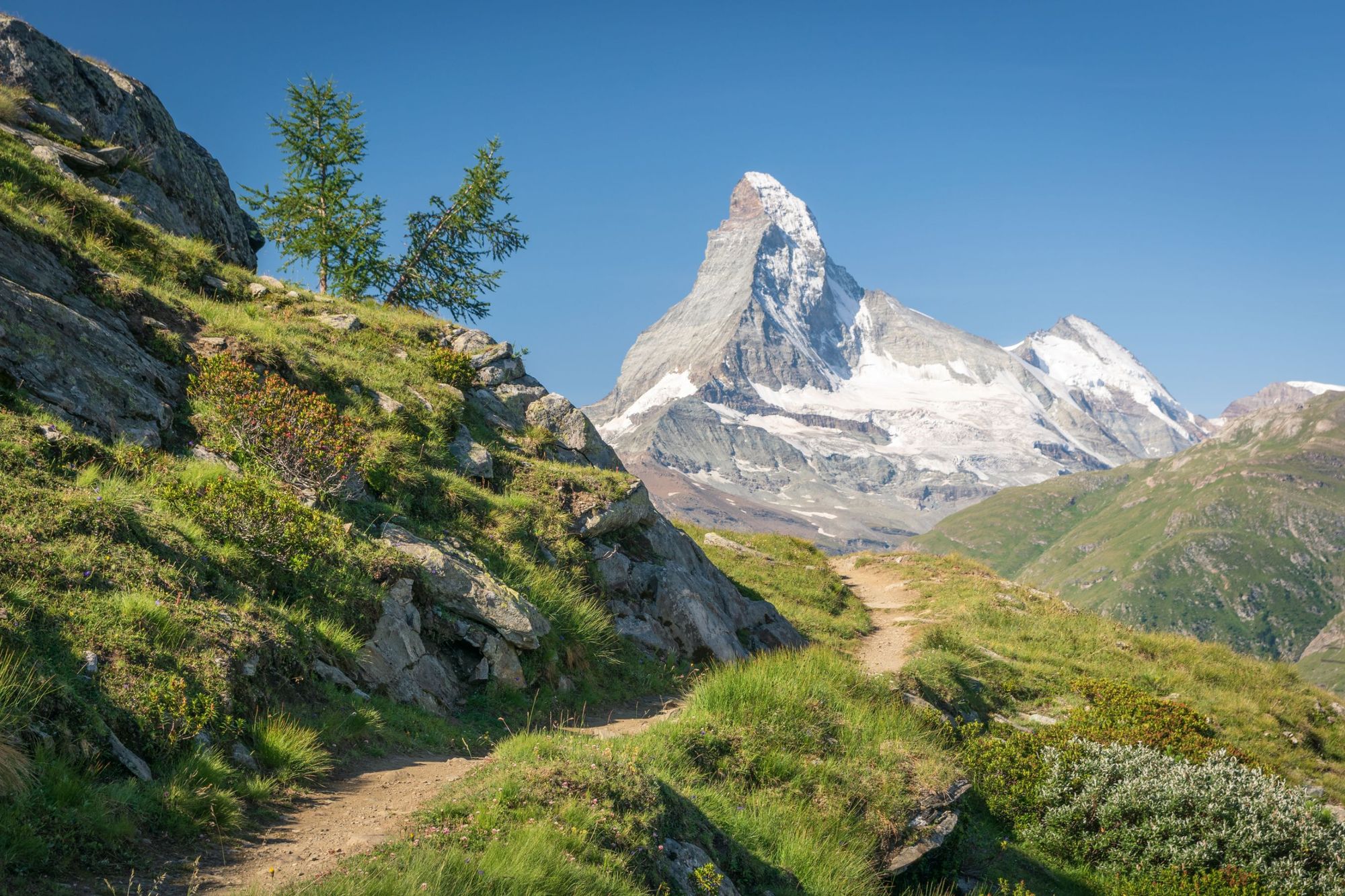 The Europaweg trail leads the eye trough lush, green meadows to the distant Matterhorn. Photo: Getty