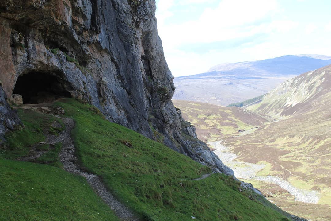 The small trail leading up to the caves, with the far-reaching view of the glen just behind. Photo: Stuart Kenny
