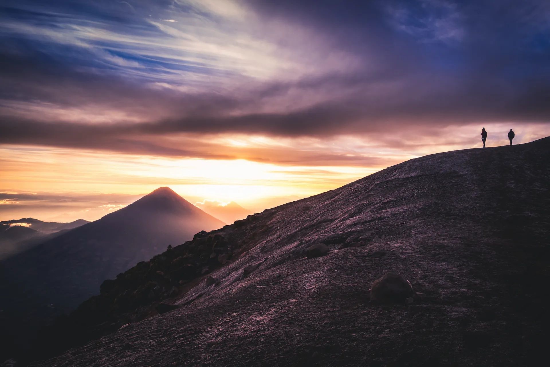 Watching the sun rise from the summit of Acatenango (Fuego Volcano in the background). Photo: iStock