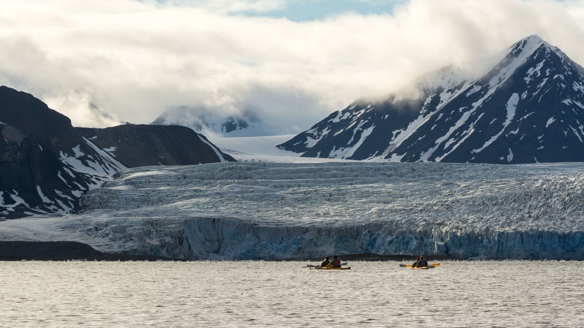 Kayakers in Svalbard, paddling towards Esmark Glacier.