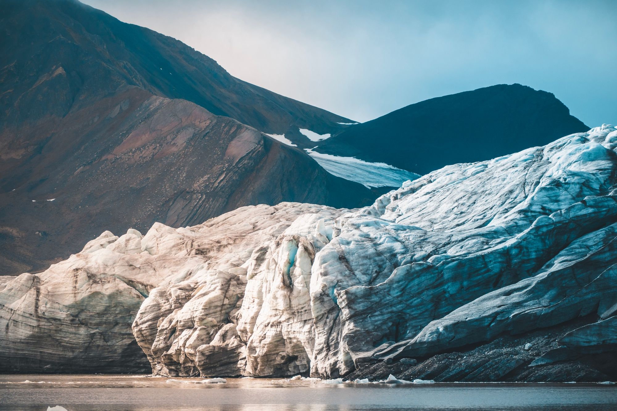 A glacier in front of the dark mountains in Svalbard