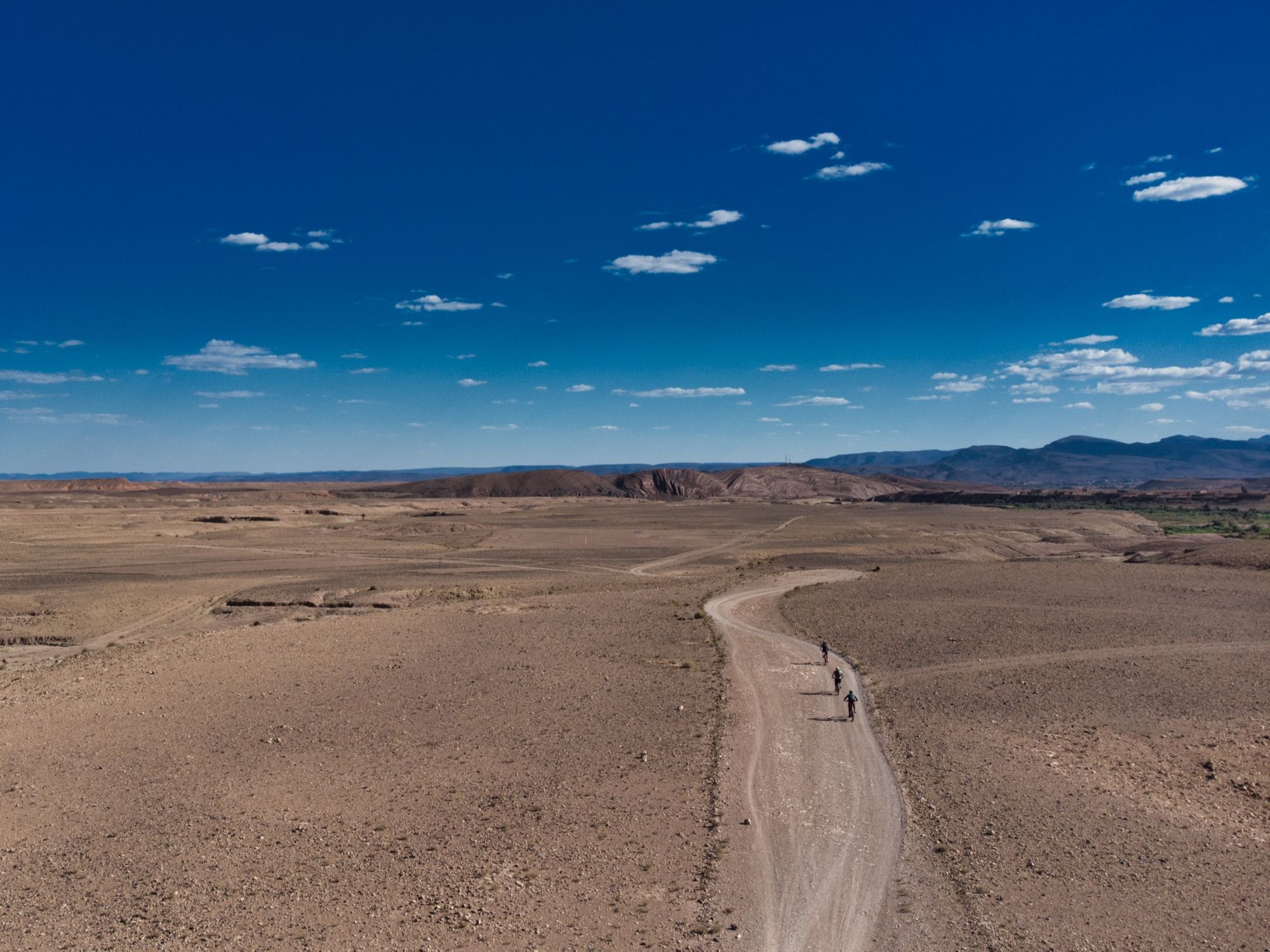 Cyclists on a road through the stone deserts of the Moroccan Sahara. Photo: Aztat Treks.