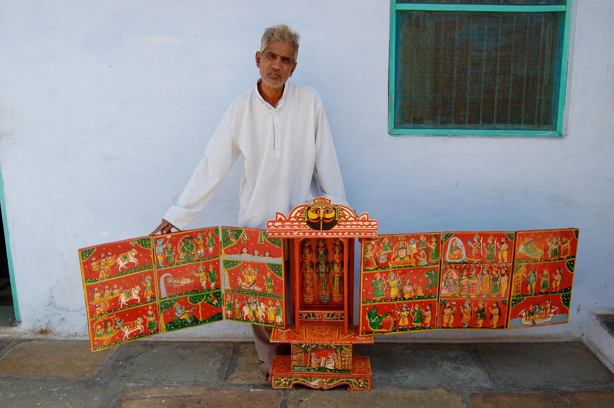 An authentic Kaavad, depicting a traditional folk tale, and a Kaavadiya Bhats storyteller. 