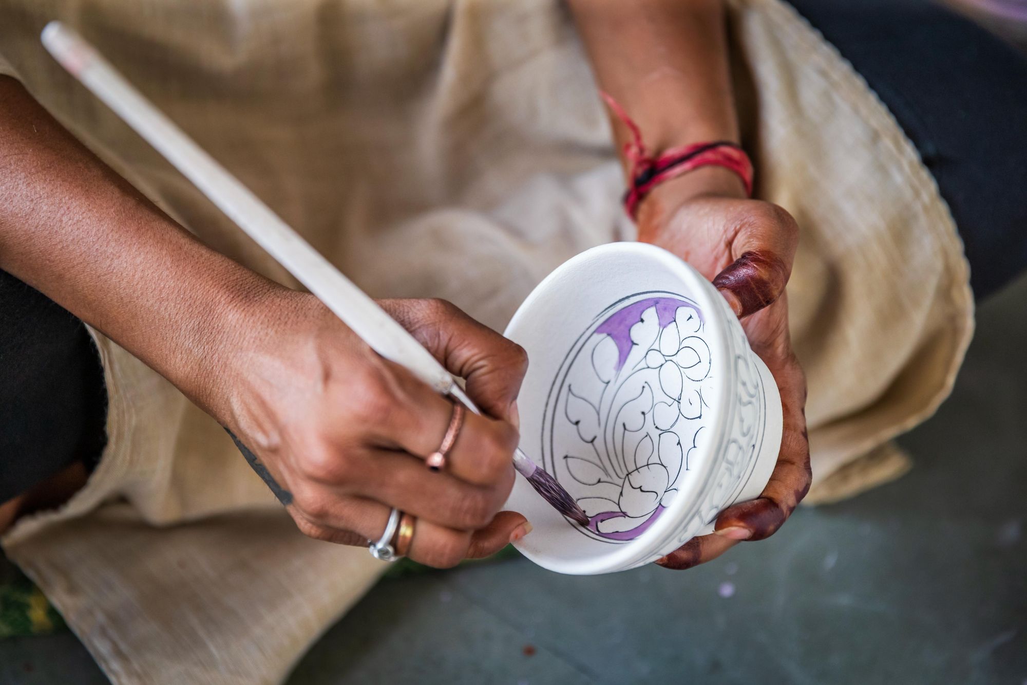 Close up of a craftsperson in Rajasthan, painting pottery. Photo: Getty