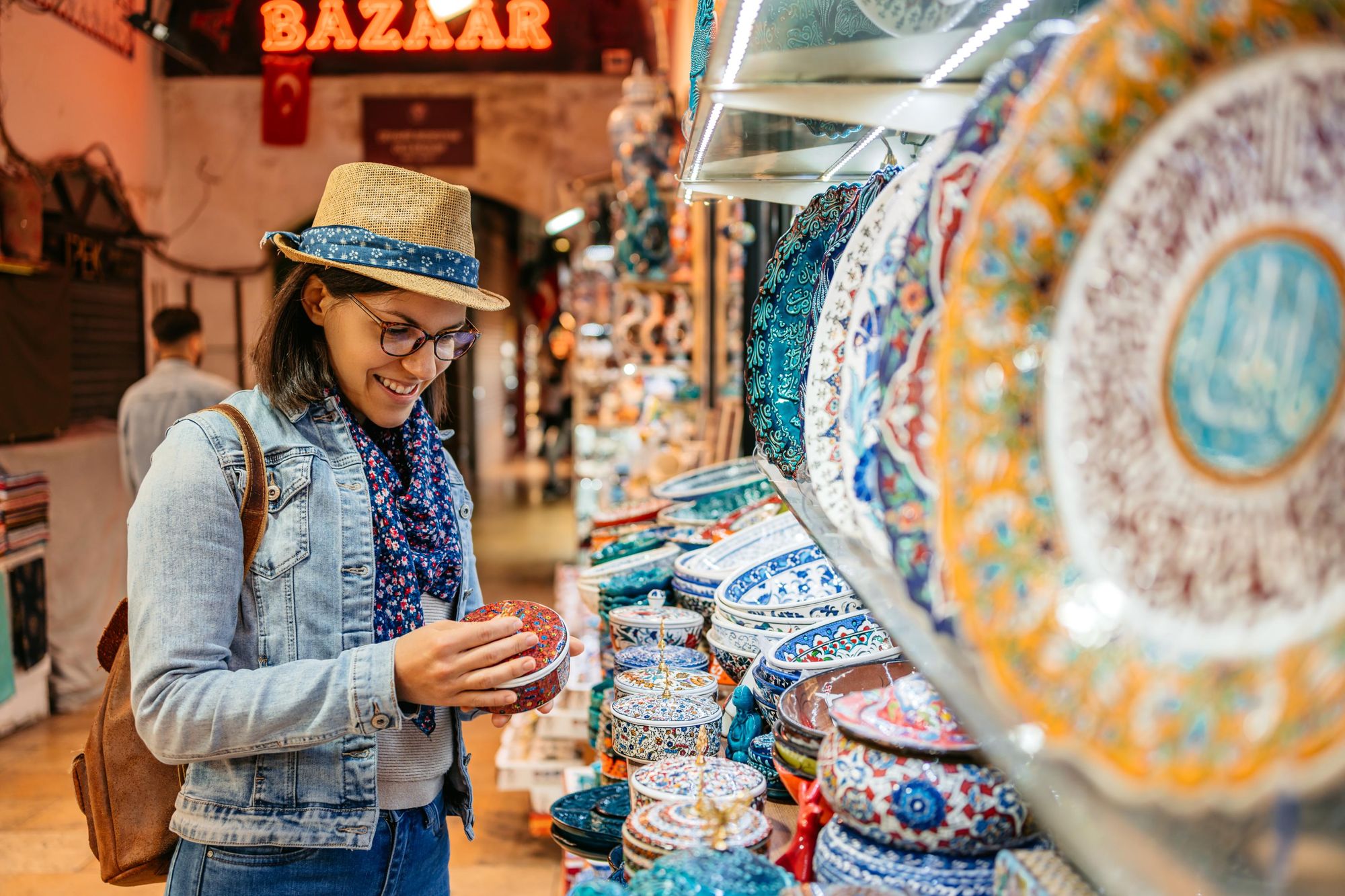 A woman looking porcelain dishes at the Grand Bazaar In Kapali Carsi in Istanbul, Turkey. Photo: Getty