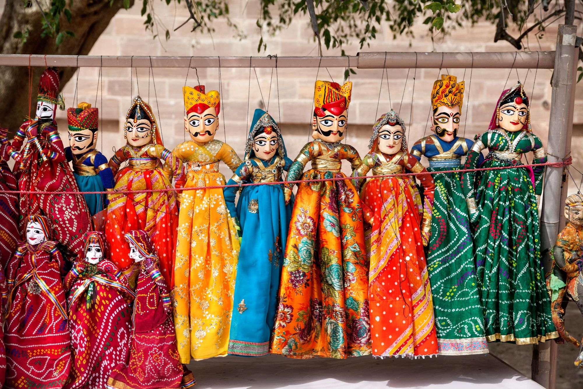 Colourful Rajasthan puppets hanging in the shop of Jodhpur City Palace, India. Photo: Getty