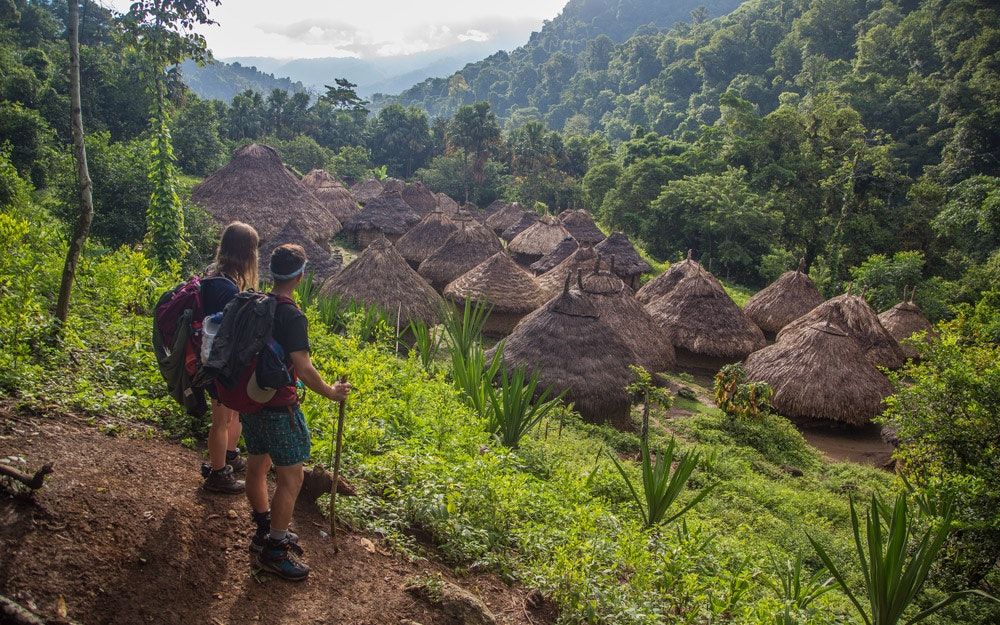 Dos excursionistas contemplan las cabañas de la tribu Viva, en lo profundo del bosque de la Sierra Nevada de Santa Marta en Colombia.  Foto: Matthew Stern / Revista Getaway