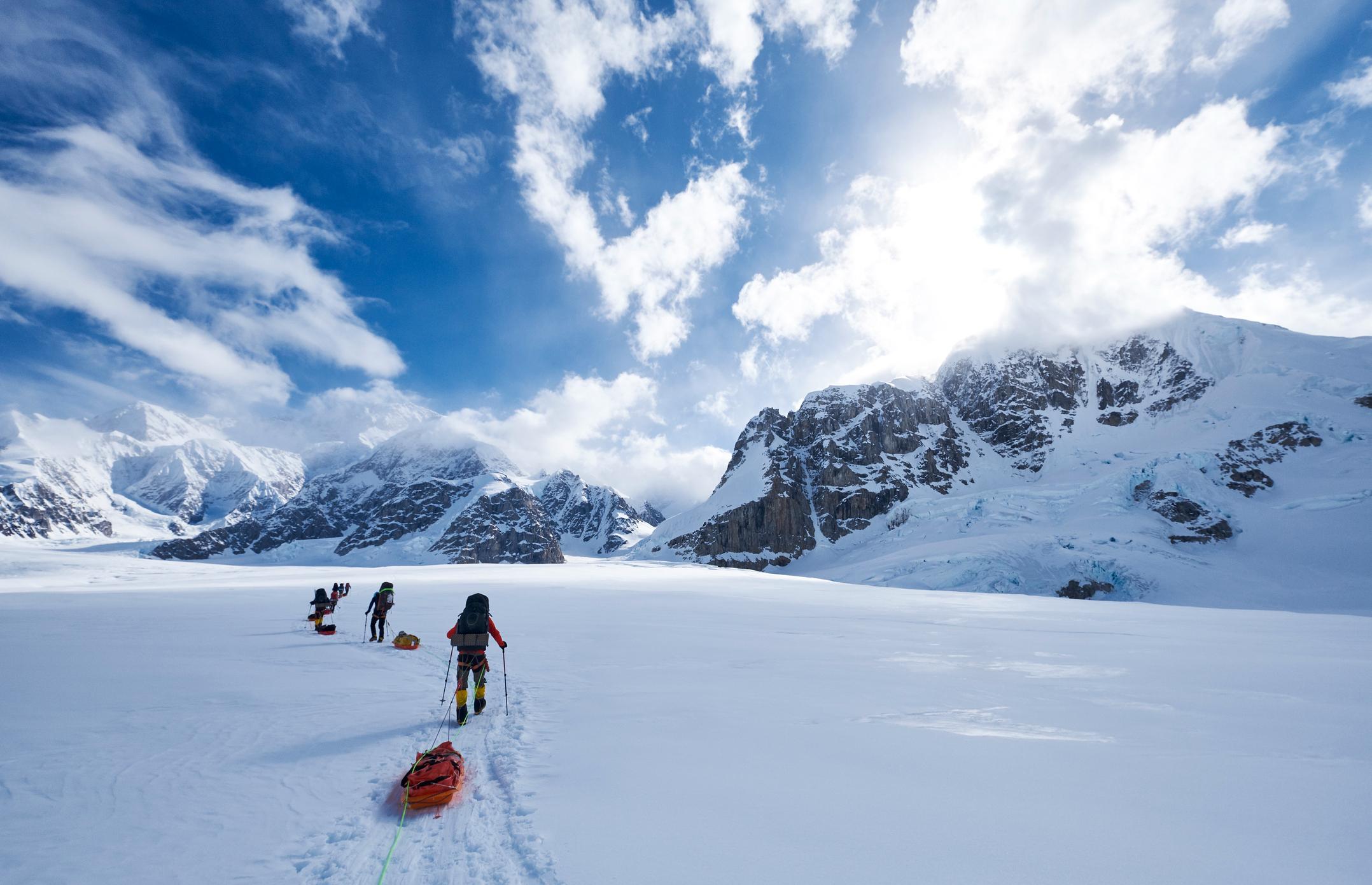 Climbers pulling sleds through snow on an expedition to climb Mount Denali, Alaska