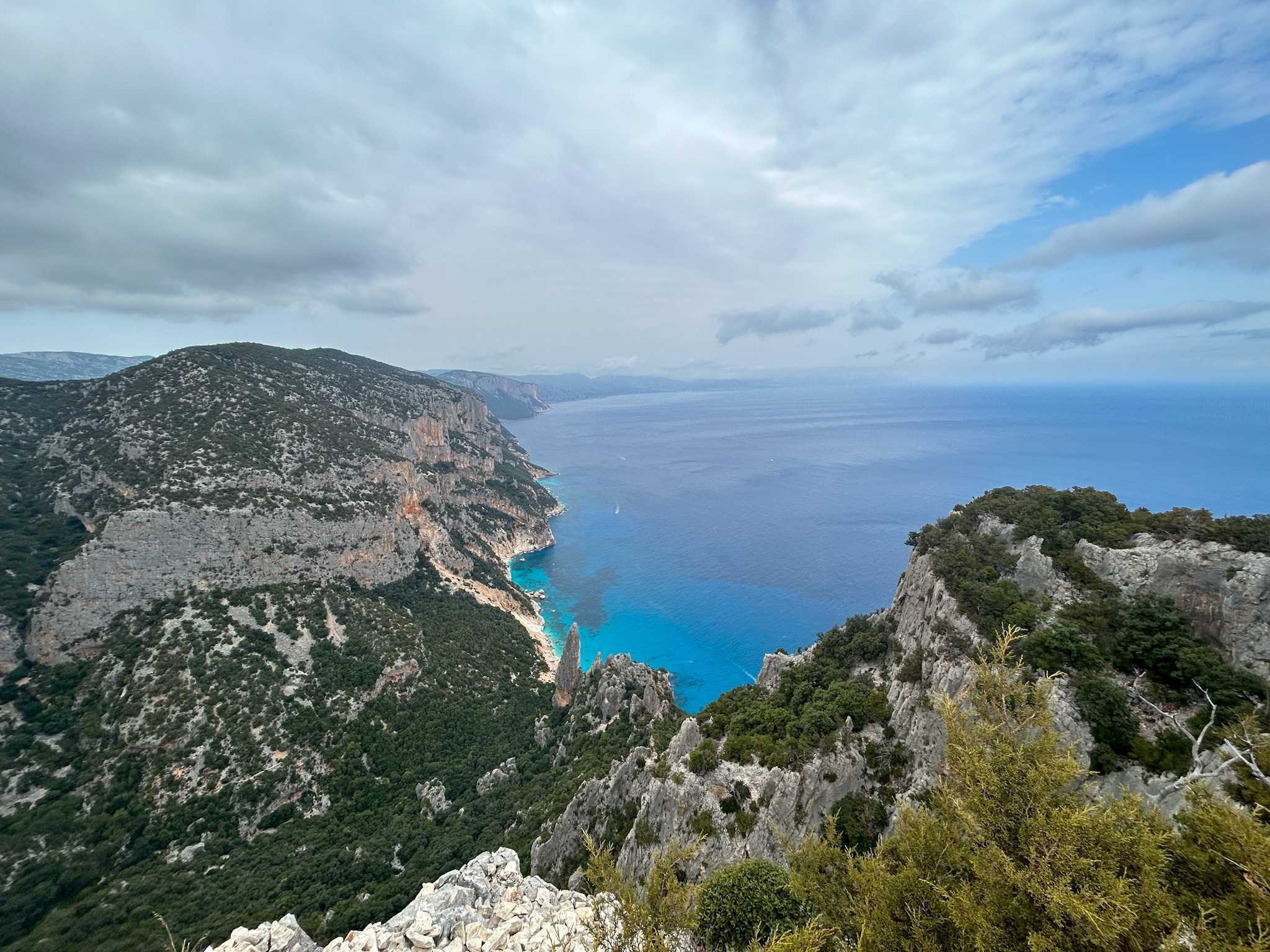 Green and grey cliffs contrasting against the turquoise sea of the Orosei Gulf, Sardinia.