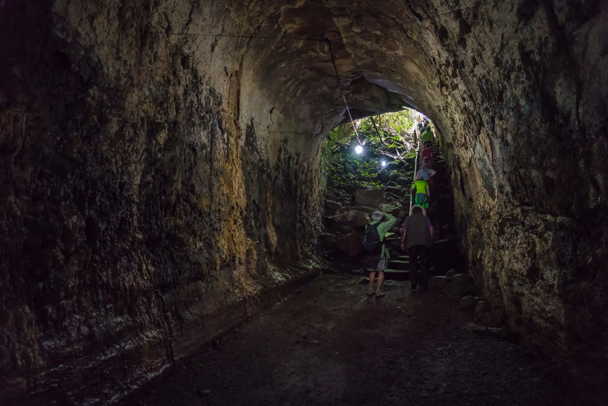 A small group of people moving through a Lava tunnel on Santa Cruz, in the Galapagos. Photo: Getty