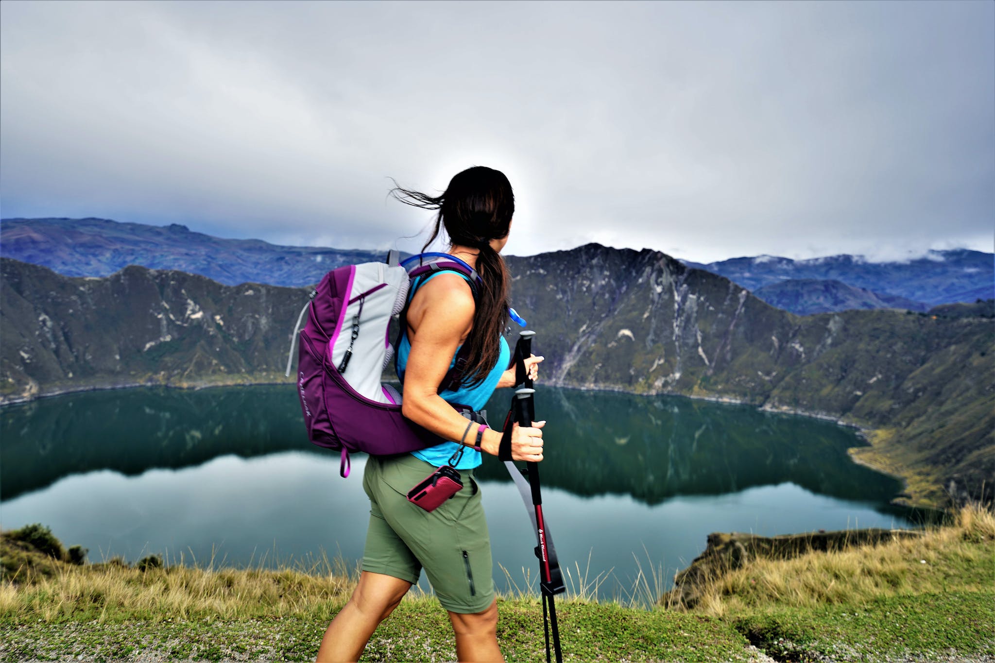 A hiker walking along the rim of Quilotoa Crater Lake.