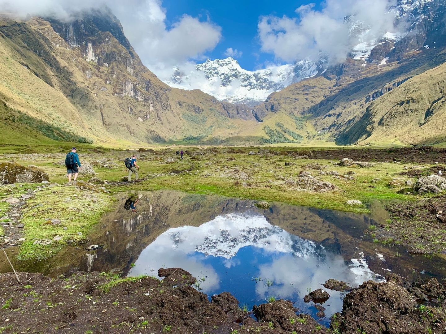 Two men trek past a lake in the Ecuadorian Andes.