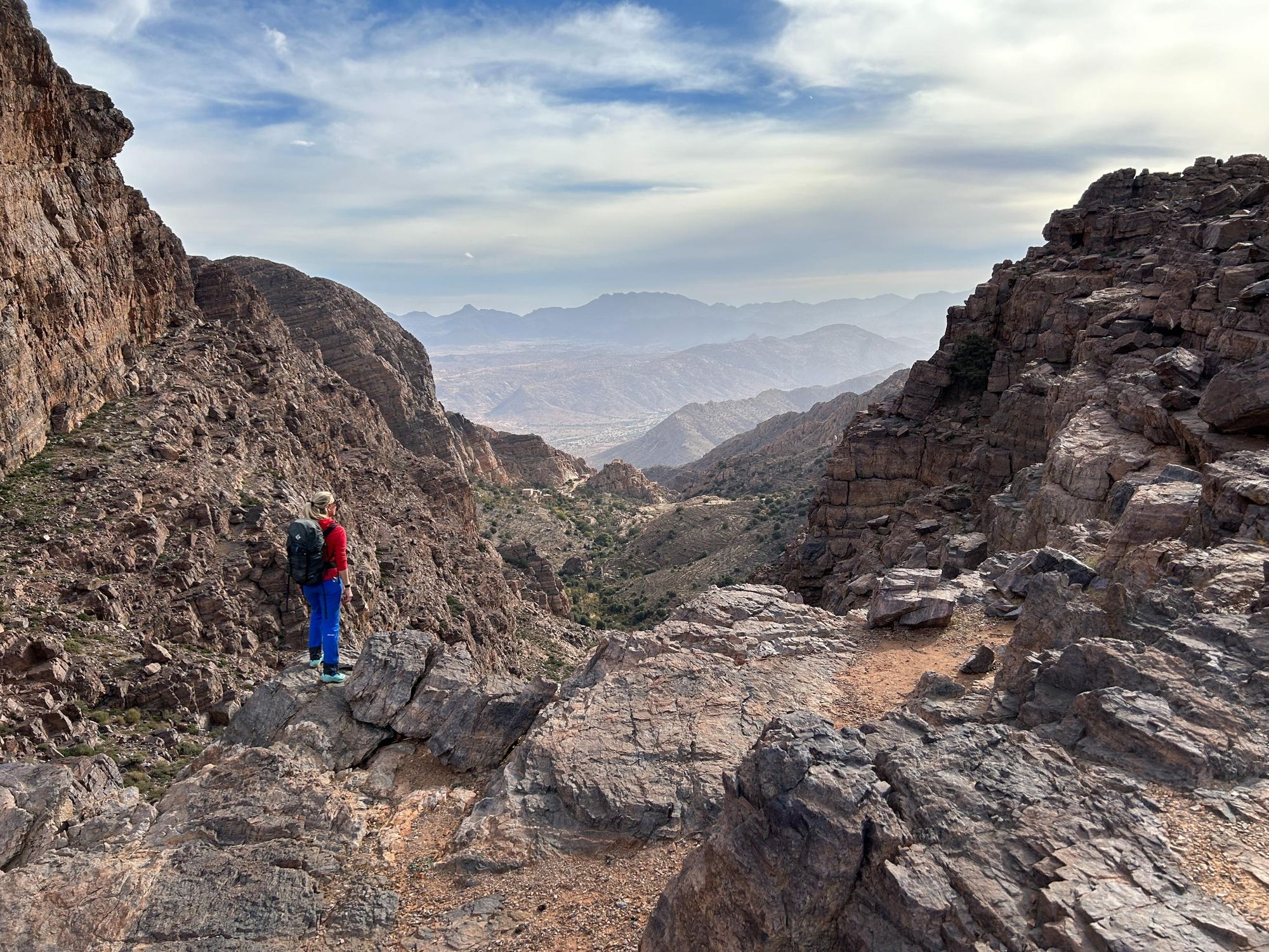 A woman stares out over a mountain range.