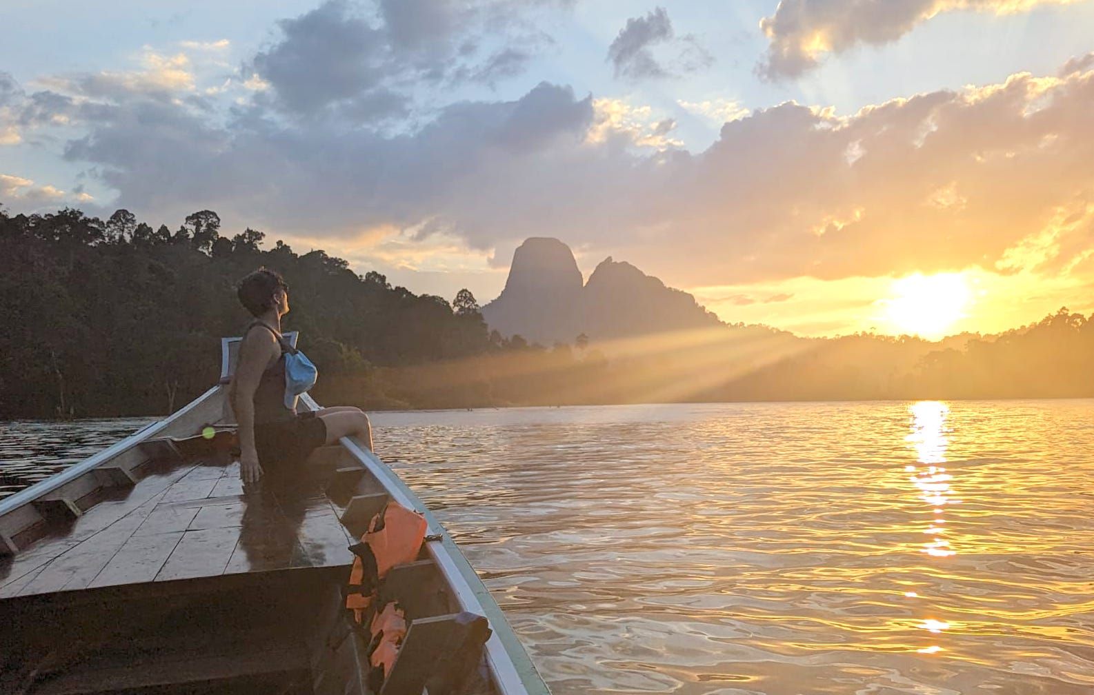 Woman at sunset on a boat trip in Cheow Larn, Thailand.
