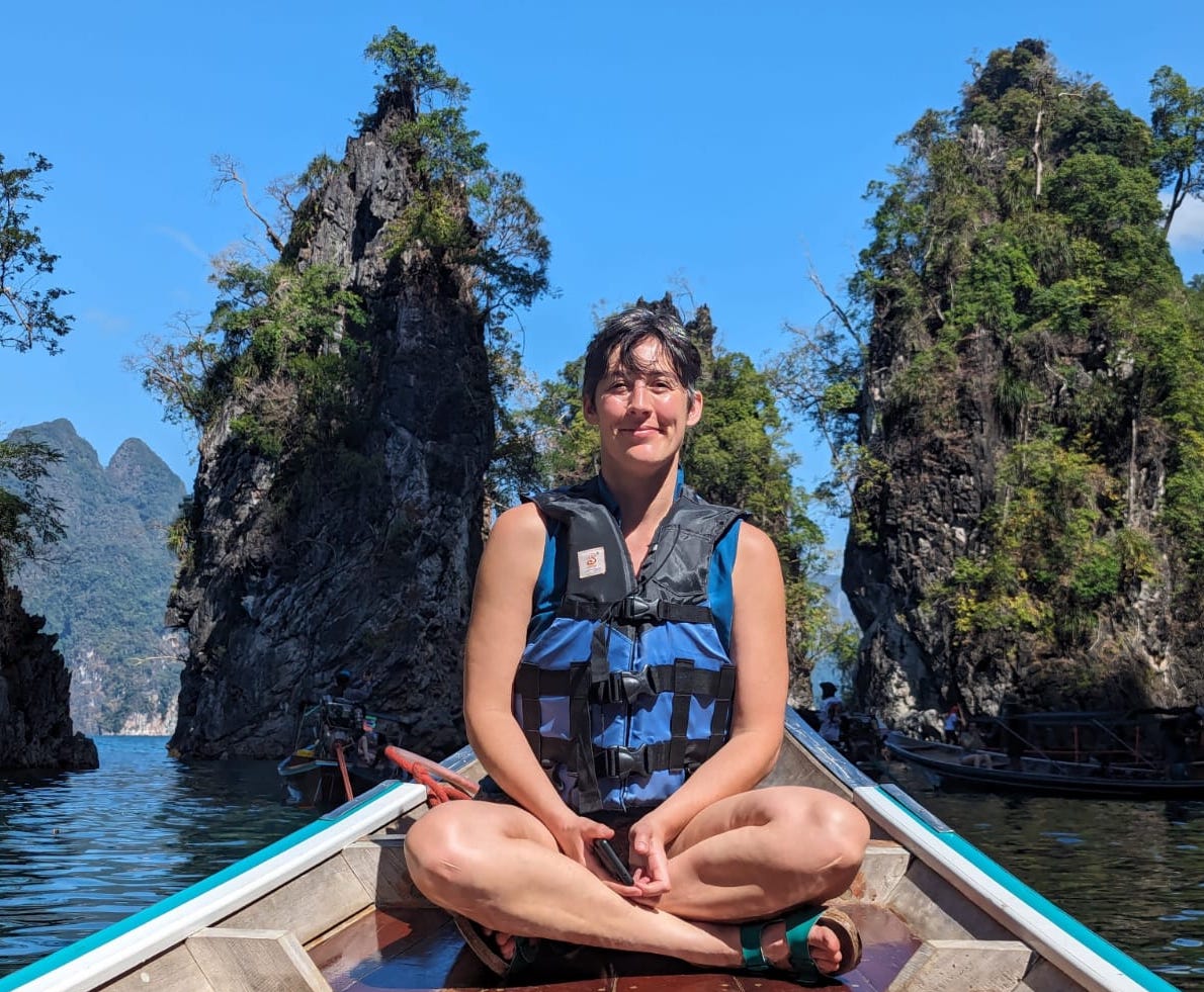 A tourist poses on a boat in Khao Sok National Park, Thailand.