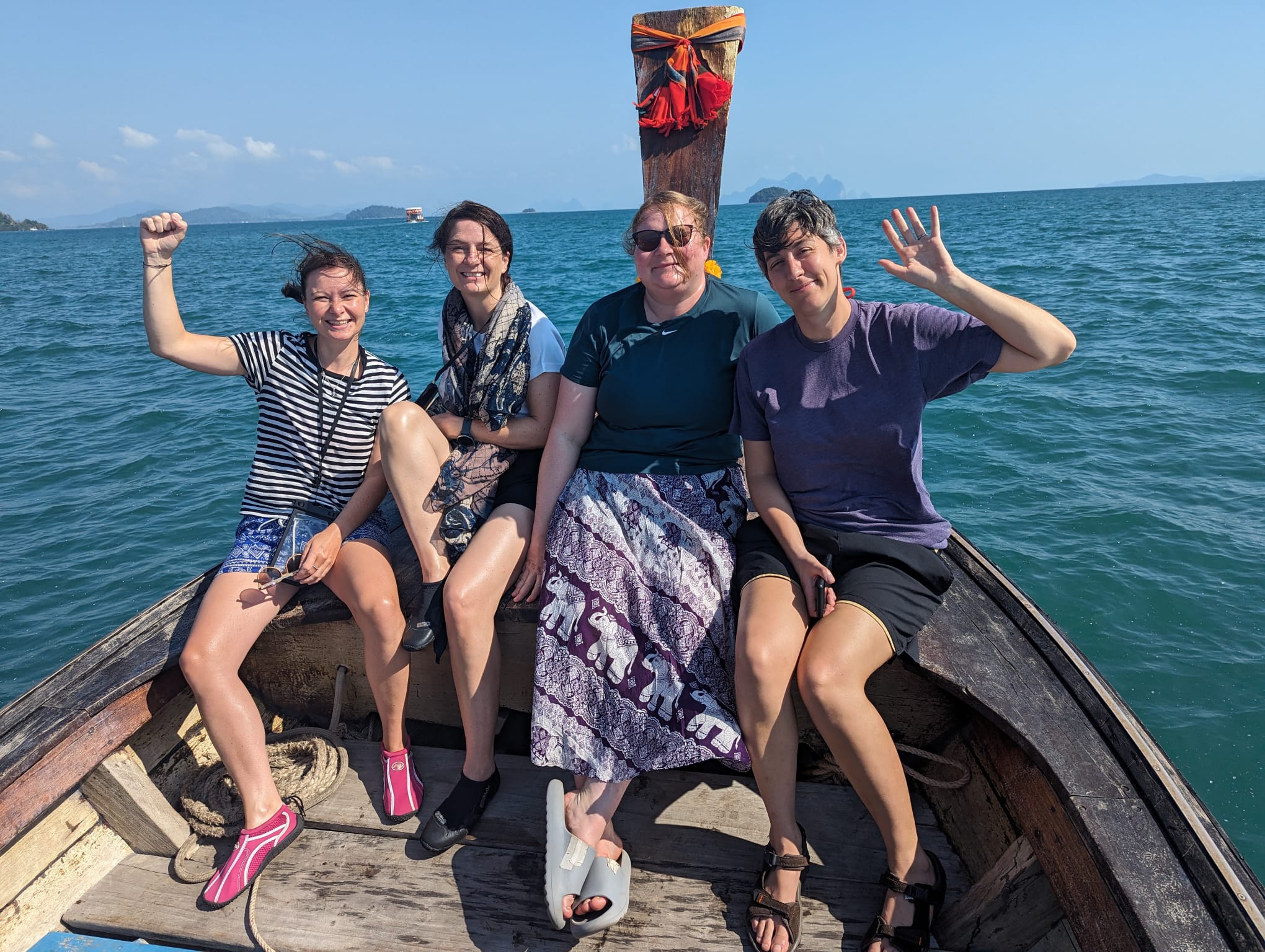 A group of female tourists pose on a longtail boat in Phang Nga