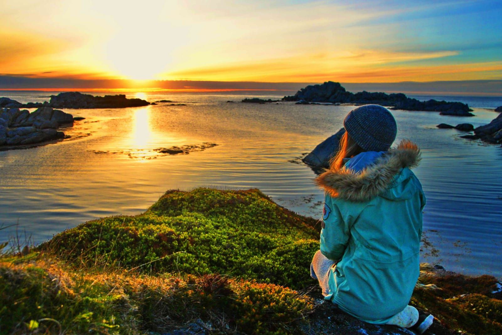 A woman watches the sun set in the Lofoten Islands, Norway. Photo: Northern Explorer.