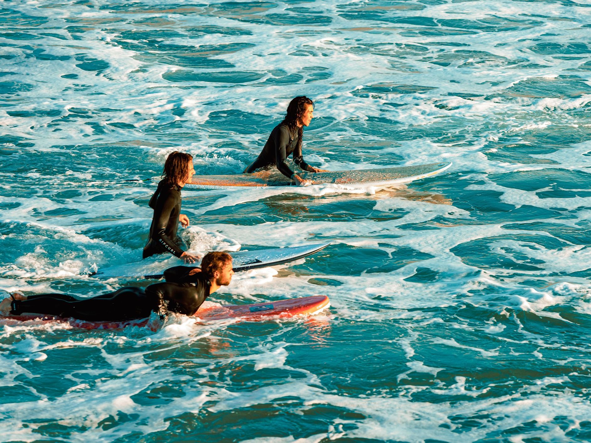 Surfers wait for a wave together.
