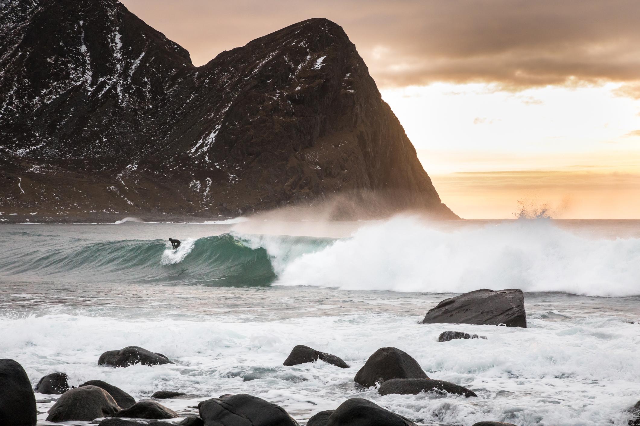 A surfer catches a wave on Unstad Beach, Lofoten. Photo: Getty.