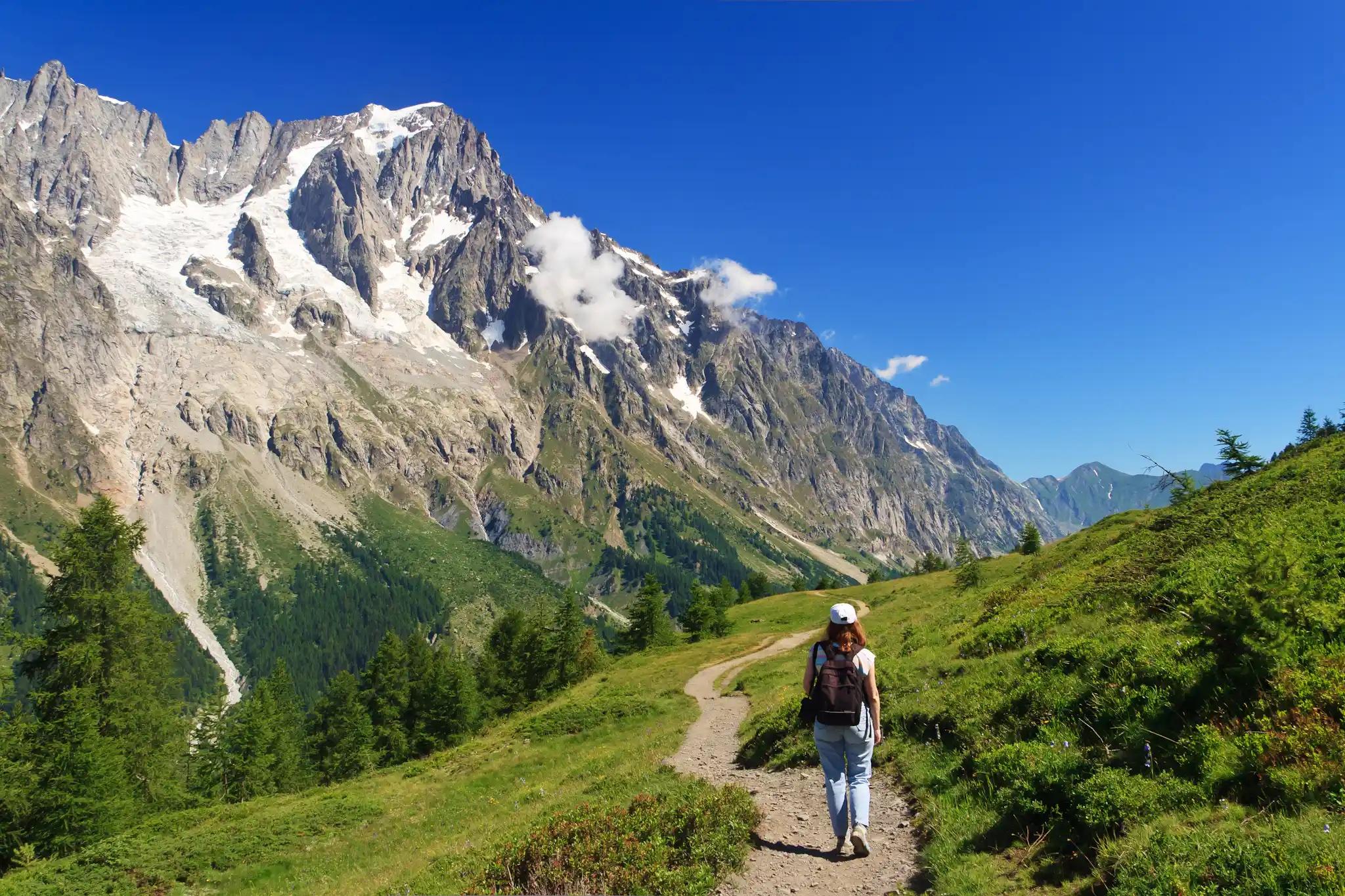 Gorgeous views of the Mont Blanc massif, with hiker walking a trail in the foreground