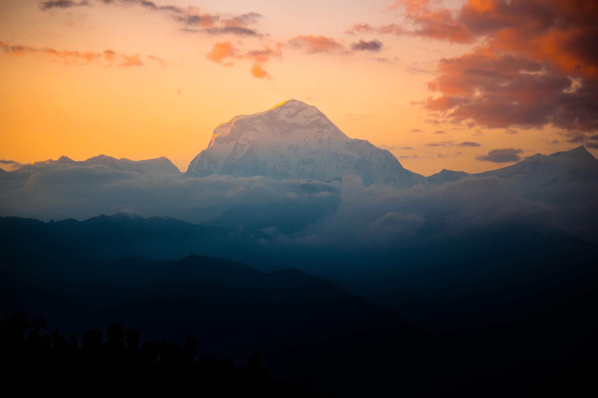The mighty Annapurna massif rises above the clouds as the sun sets in Nepal. Photo: Josh Edwards