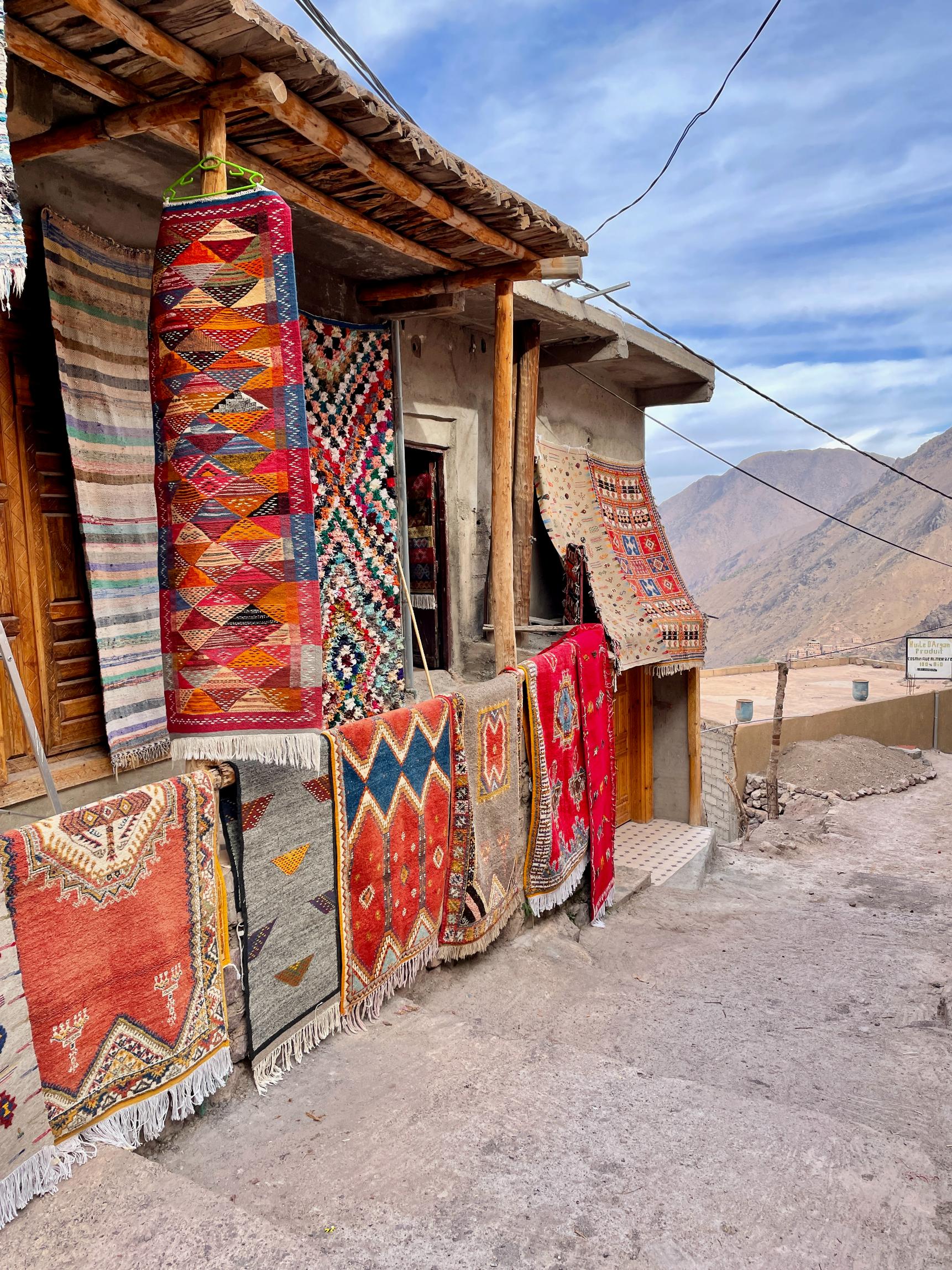 Colourful Berber carpets hanging on display at Moroccan shop in the High Atlas Mountains. Photo: Getty