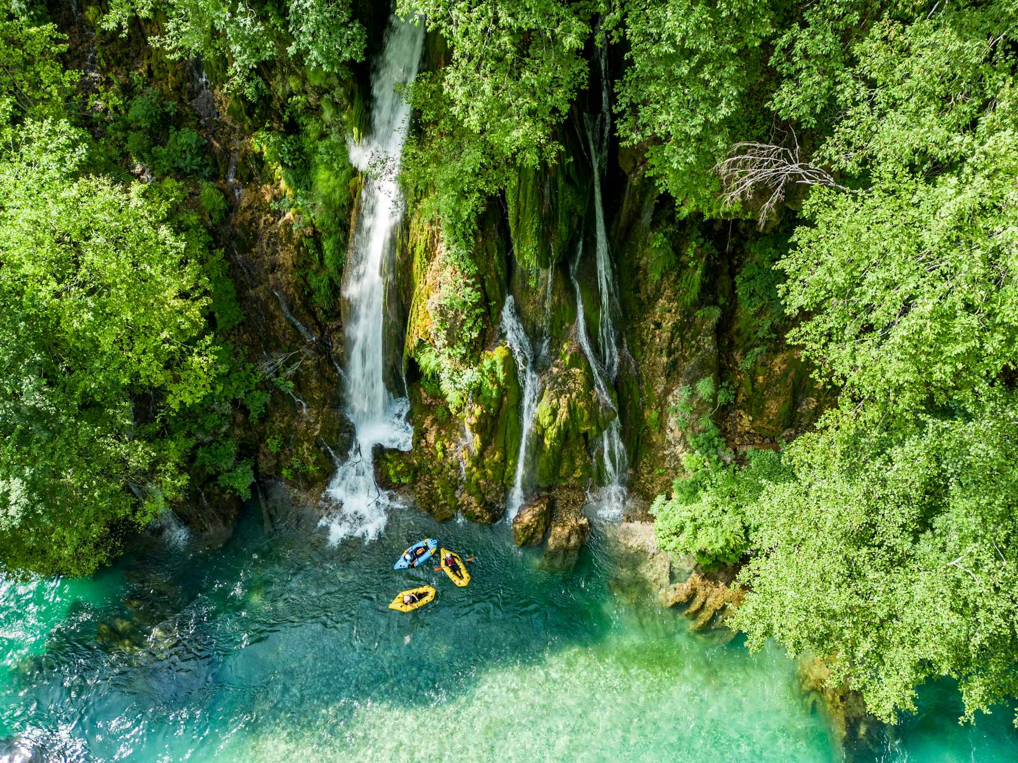 A gentle segment on the Tara River in Montenegro, beneath a tall waterfall. Photo: Balkan Expeditions