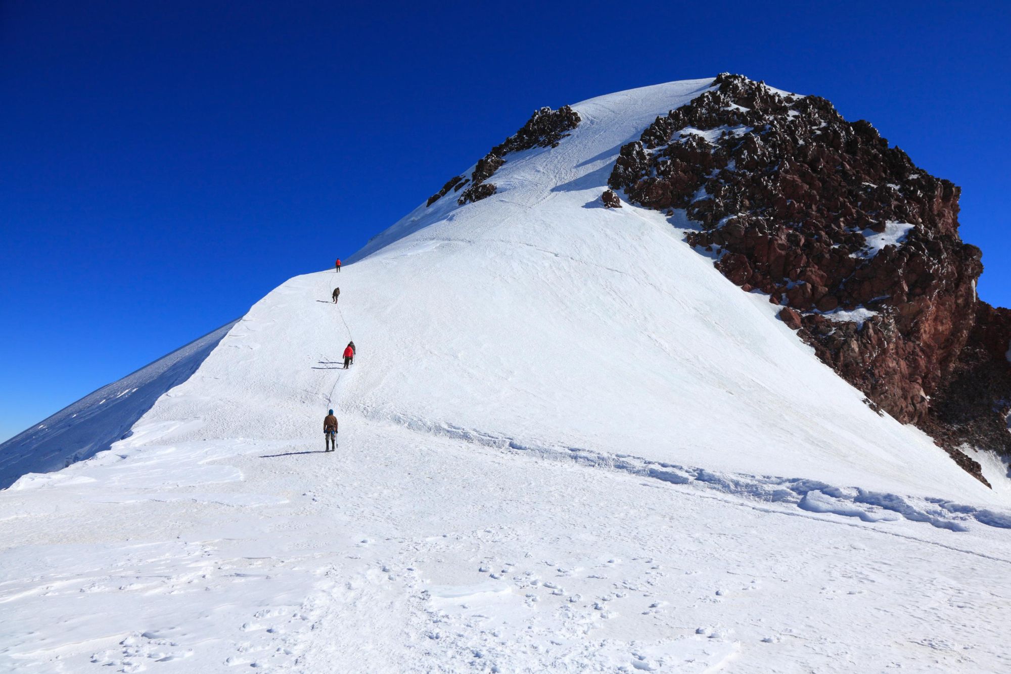 Hikers climbing to the summit of Mount Kazbek, Georgia