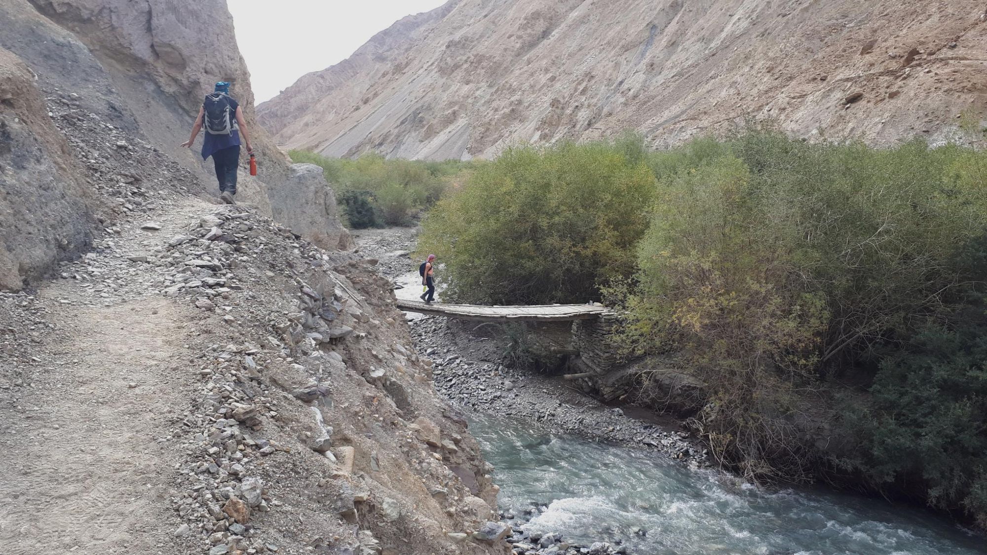 A hiker using a wooden bridge to cross over the Markha River. Photo: Dani Redd