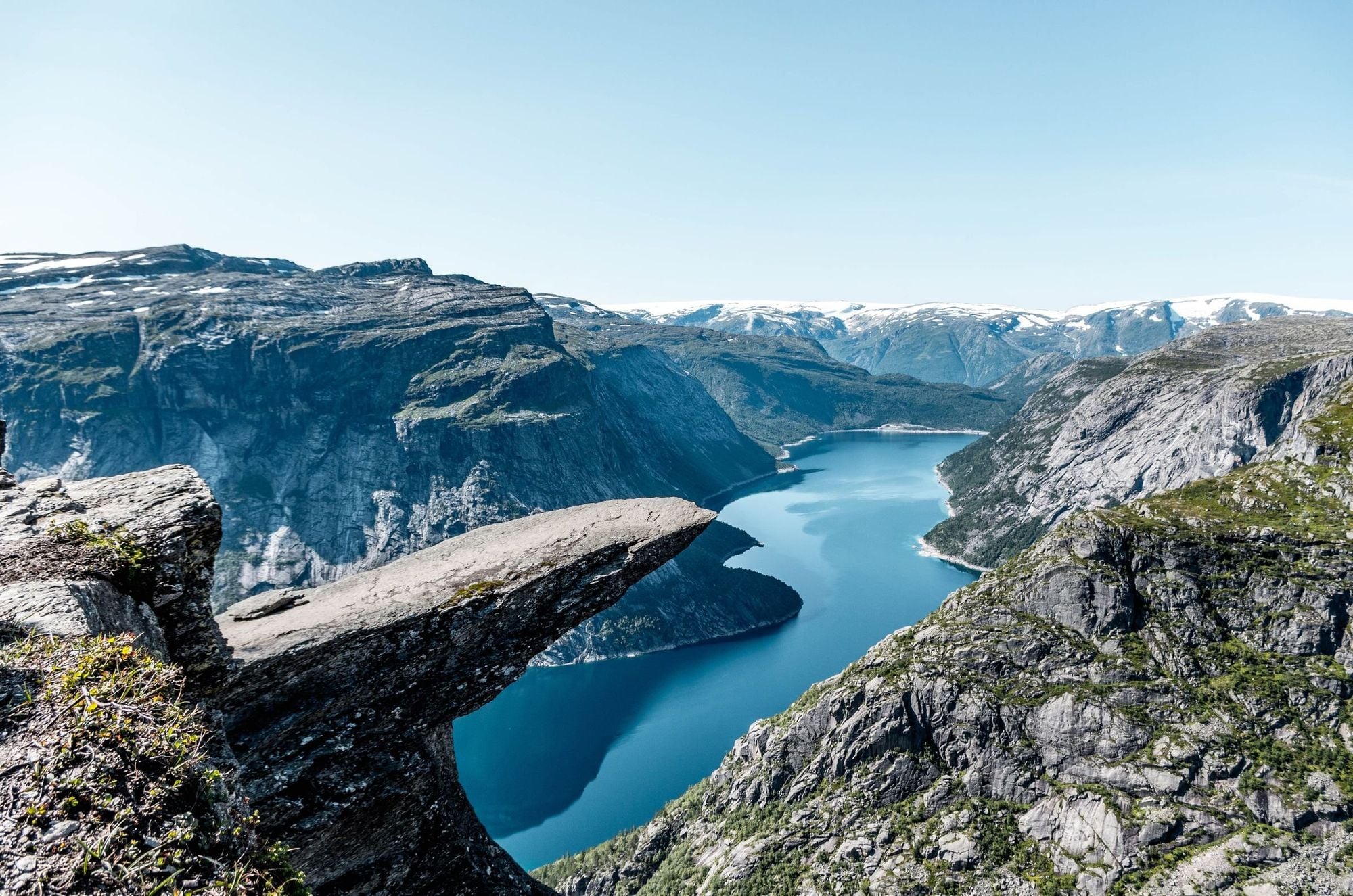 Trolltunga rock formation jutting out over Lake Ringedalsvatnet with dramatic Norwegian mountain landscape