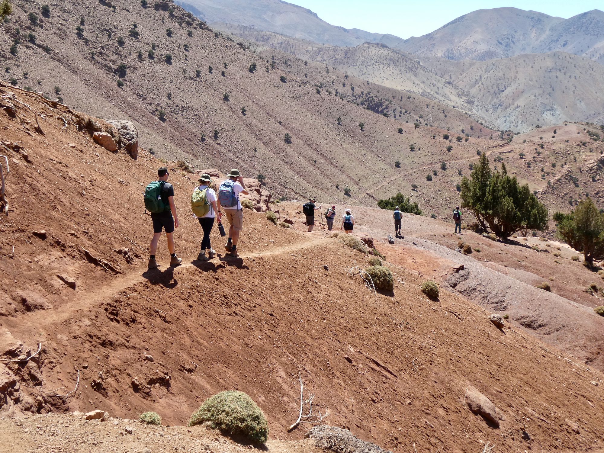 Hikers in the sparse landscape of Morocco's Atlas Mountains.