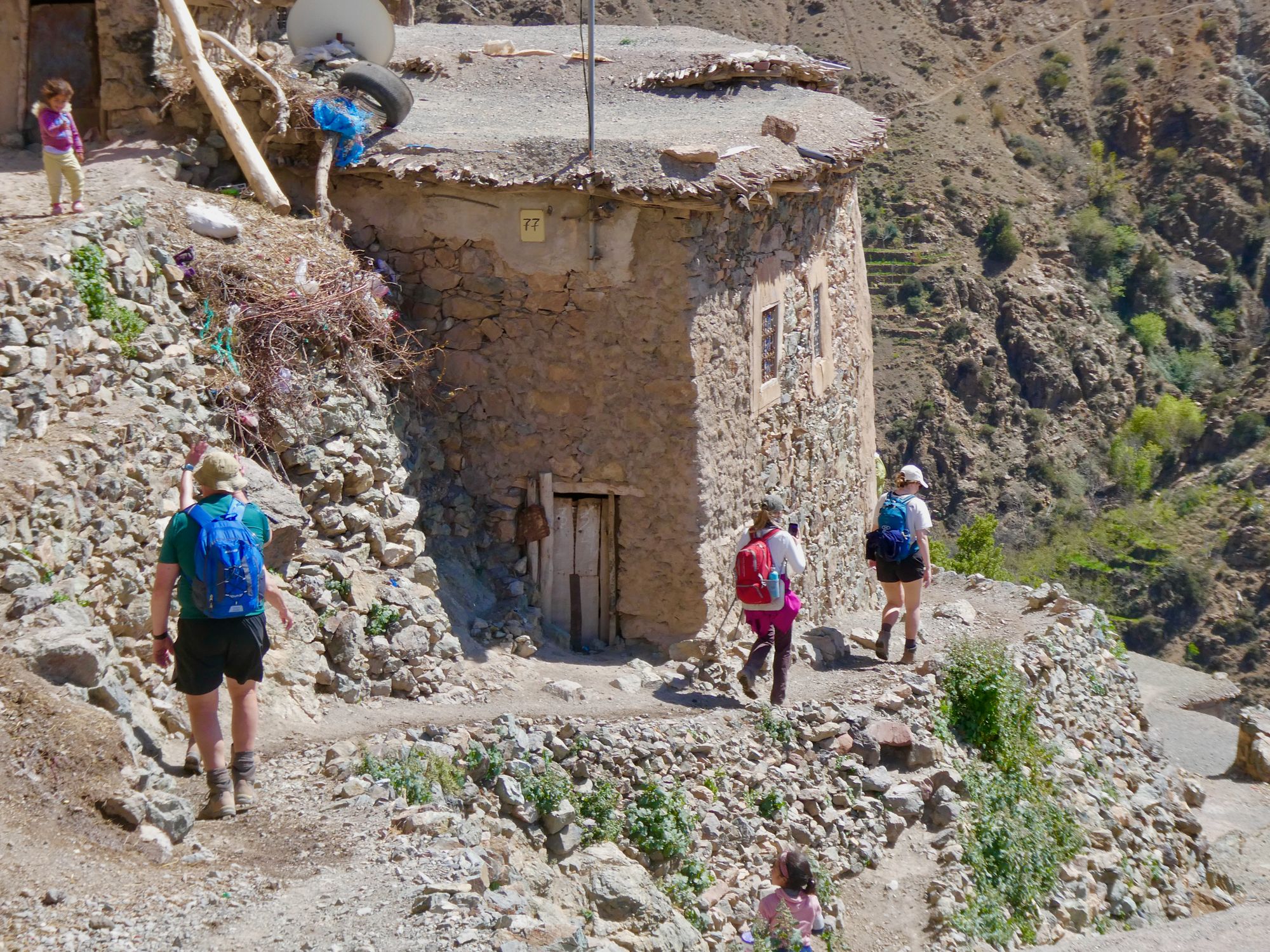 A small child waving at hikers in a village in Morocco's Atlas Mountains.