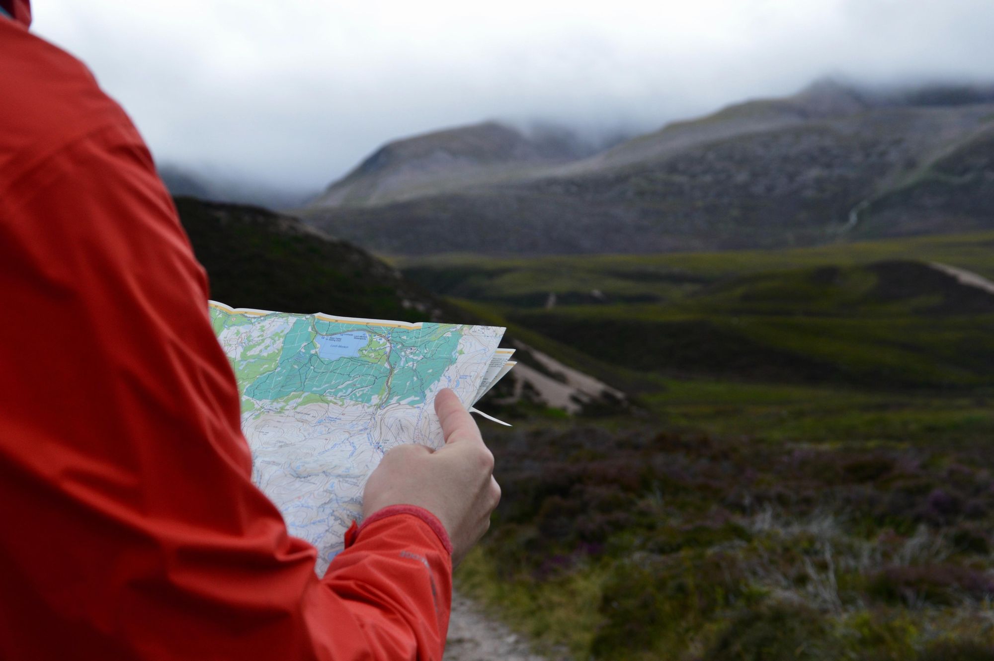 A hiker reading a map in the Cairngorms. Photo: Ali Elliott/ Unsplash.