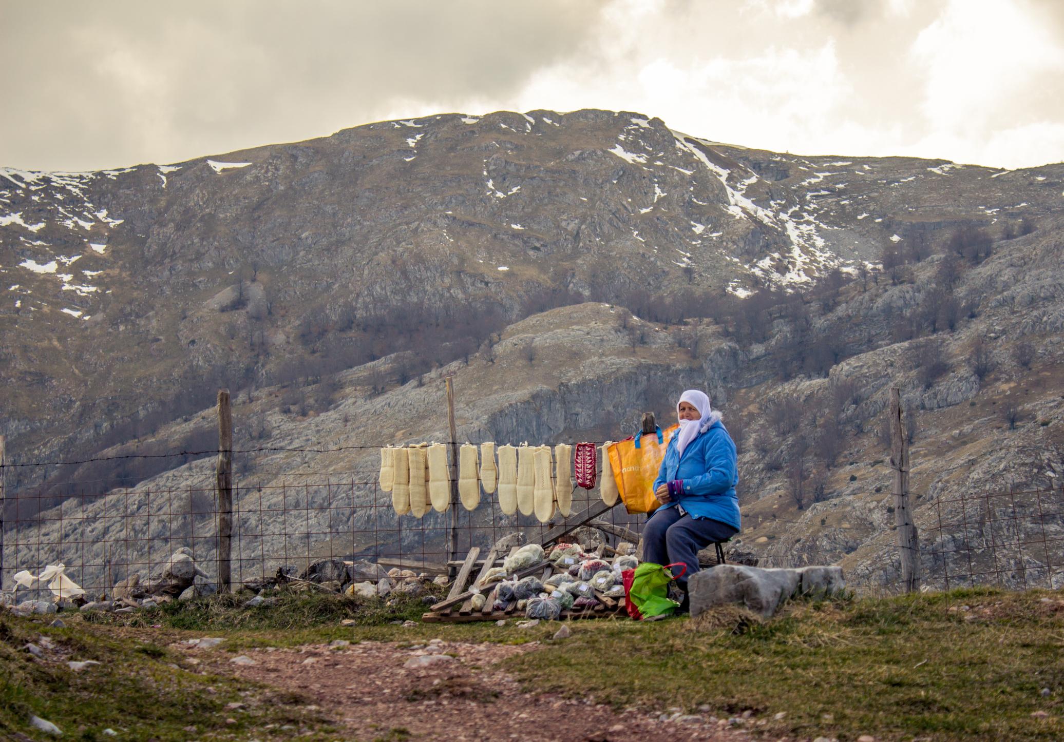 A local woman sells hand-knitted, thick woolen socks in Lukomir. Photo: Getty