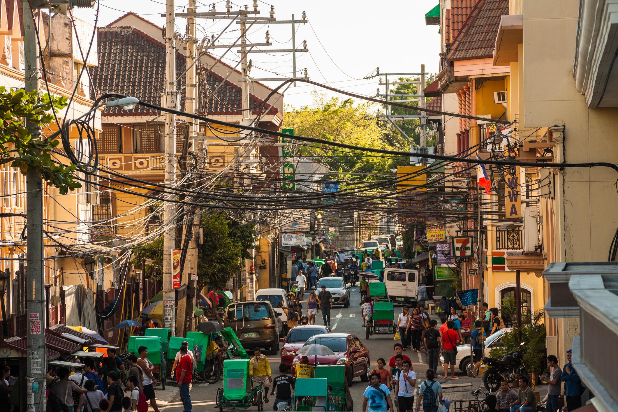 A busy street in bustling Intramuros, Manila, lined with market sellers and parasols. Photo: Getty
