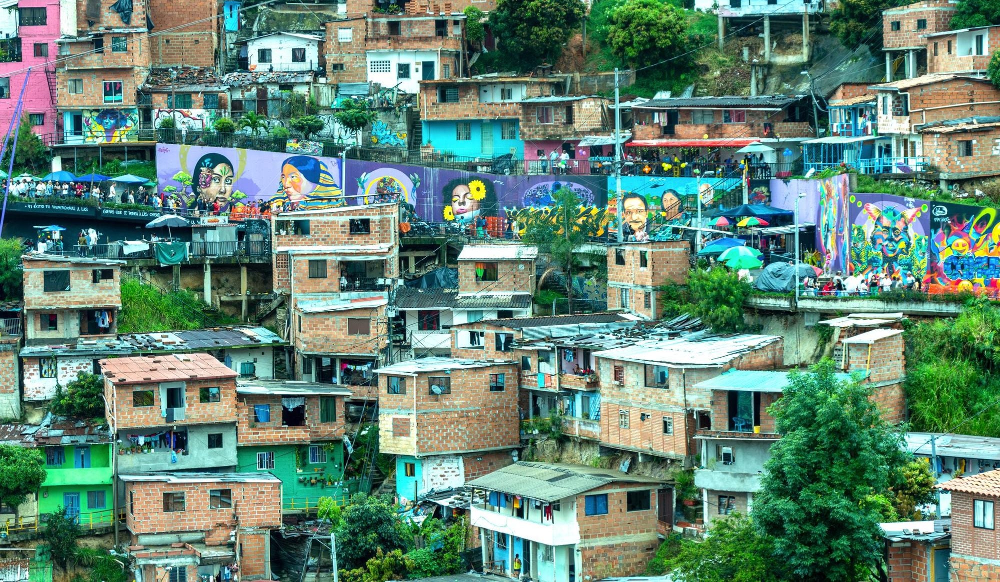 An aerial view of Comuna 13, with brightly coloured murals and visitors lining the streets. Photo: Getty