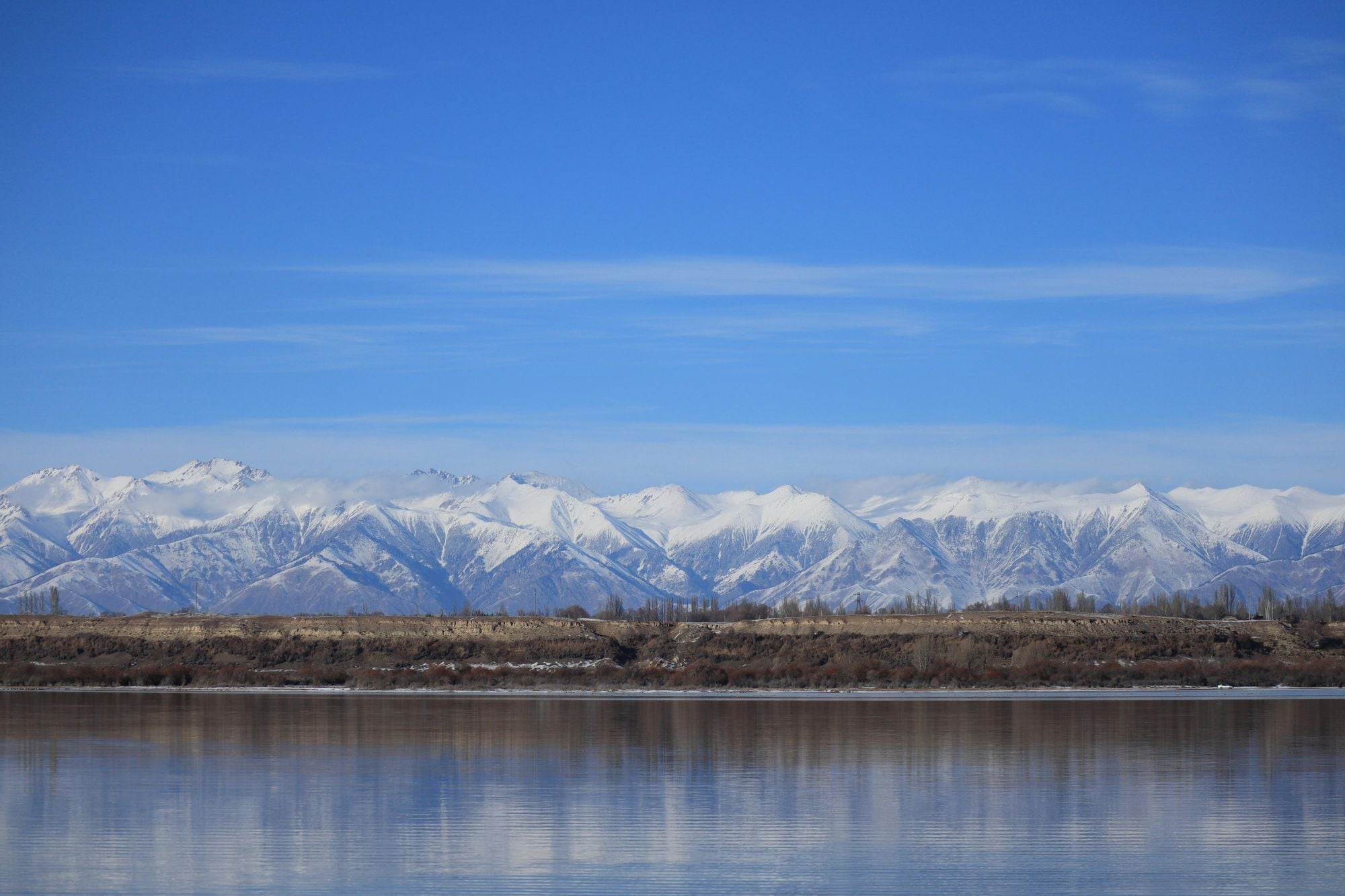 Issyk Kul in Kyrgyzstan, with the vast mountains behind. Photo: Igor Tverdovskiy via Unsplash