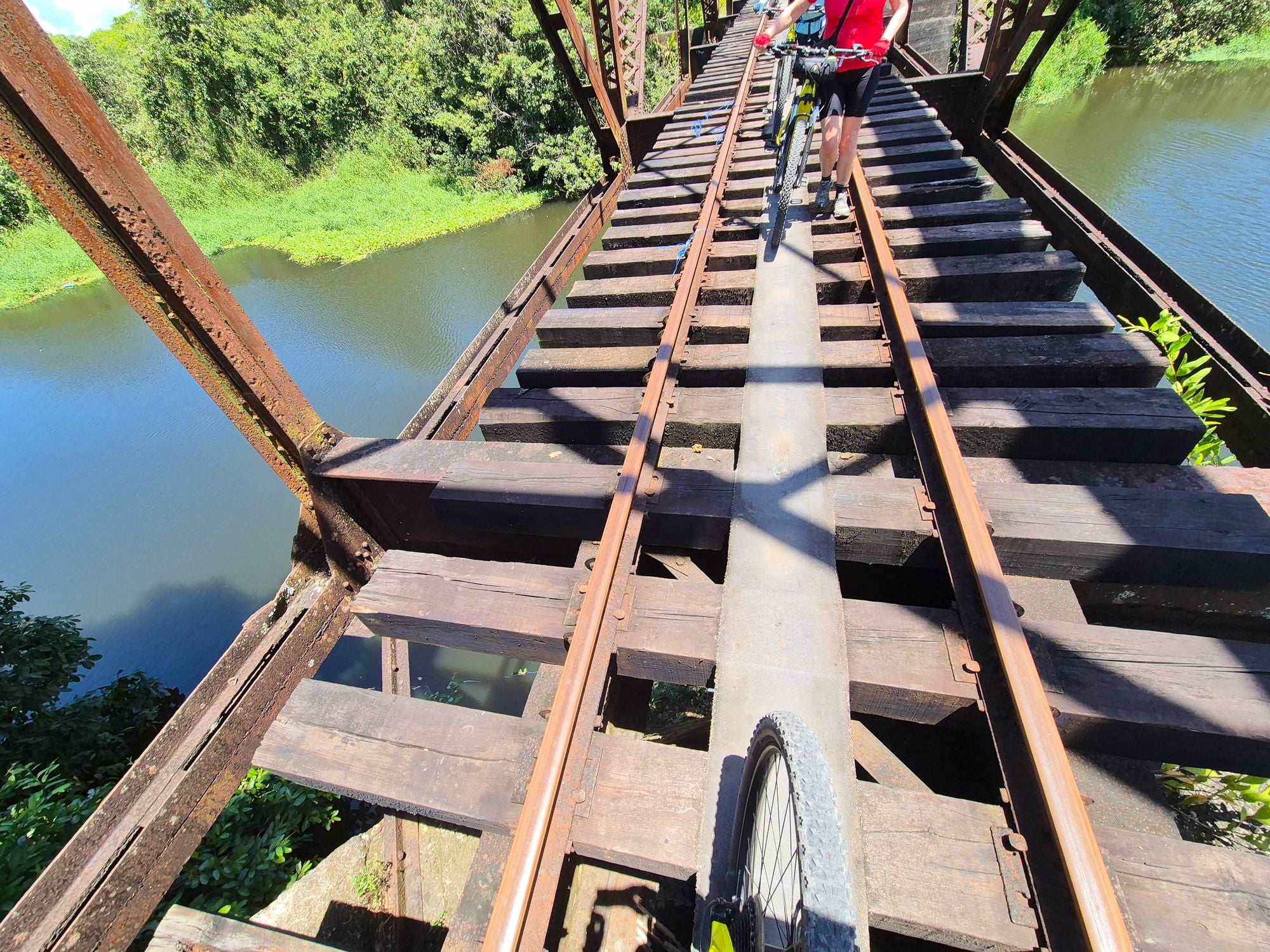 A wooden railway bridge in Costa Rica being crossed by cyclists.