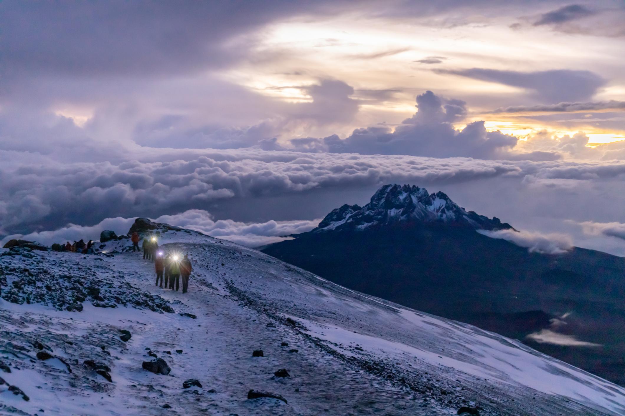A group moves along the high slopes of Mount Kilimanjaro as the morning light arrives. Photo: Getty