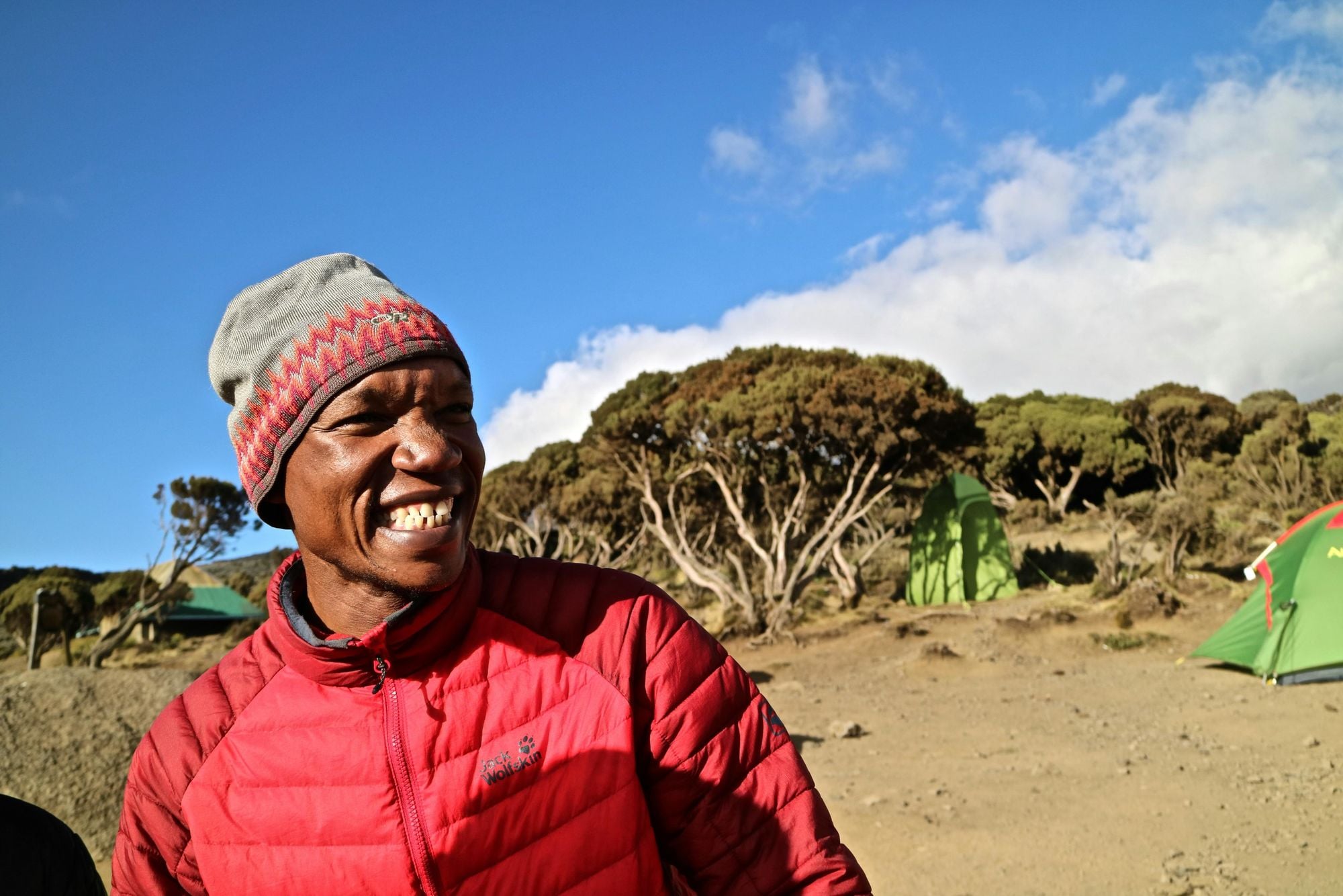A happy guide at the end of a day of hiking on Mount Kilimanjaro. Photo: Tom Cleary via UnSplash