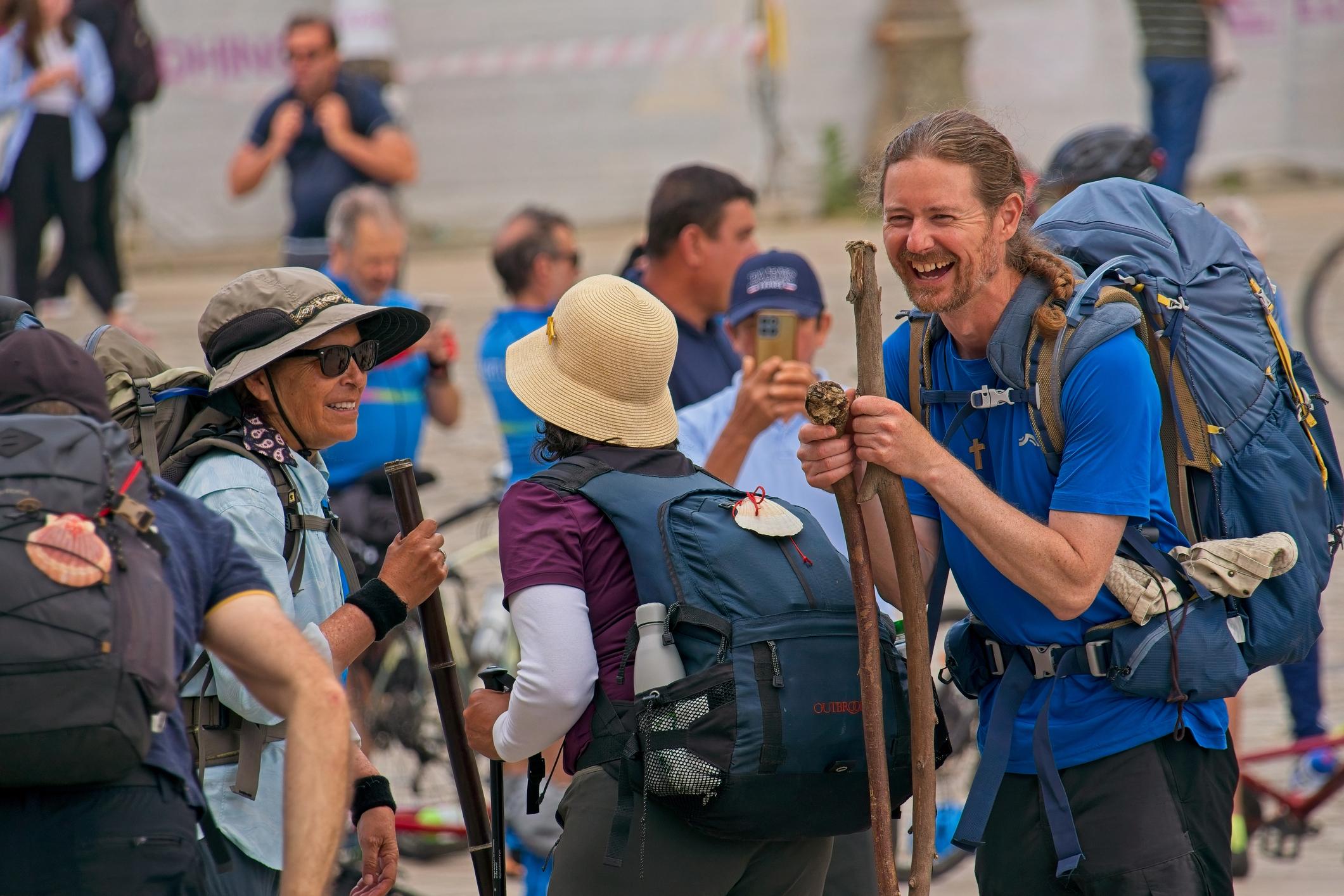 A group of pilgrims laughing after finishing the final 100km of the Camino de Santiago. Photo: Getty