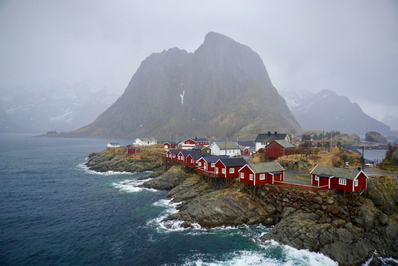 Storms break and mountains rise around the traditional red rorbu houses of the Lofoten Islands. Photo: Ross Brannigan
