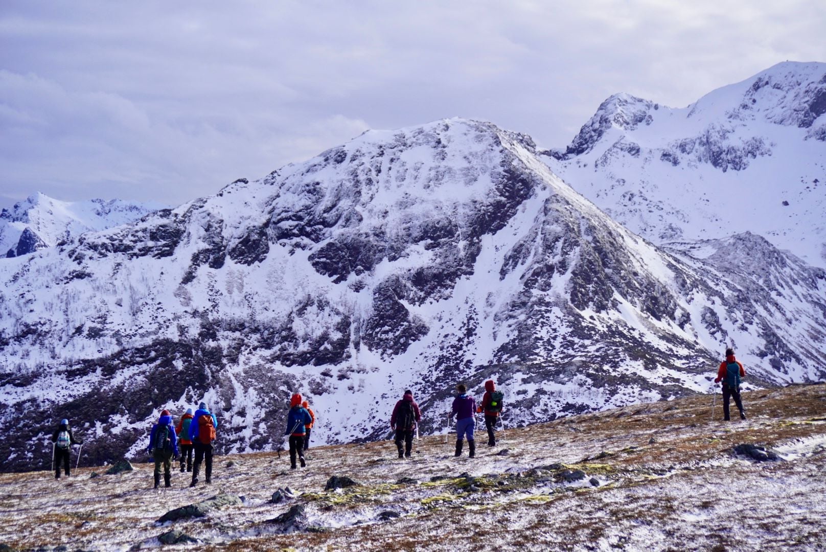 A white wall of mountains rises up beyond a high trail in the Lofoten Islands of Norway. Photo: Ross Brannigan