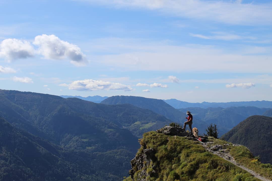 A lookout over the lush greenery above Podbrdo, with a mountain guide and his mountain rescue dog. Photo: Stuart Kenny