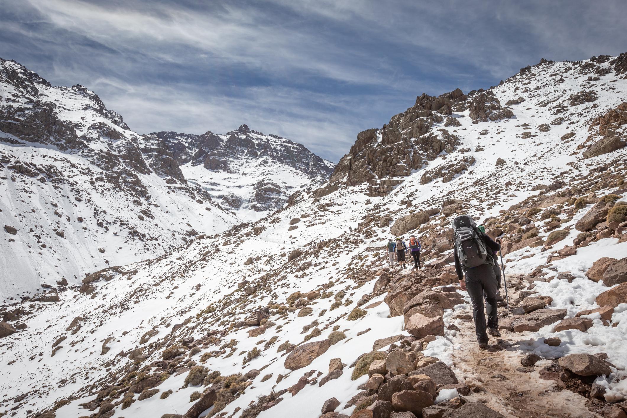 A group of hikers head through the snow-capped mountains of the Atlas Mountains, on the way to Toubkal. Photo: Getty