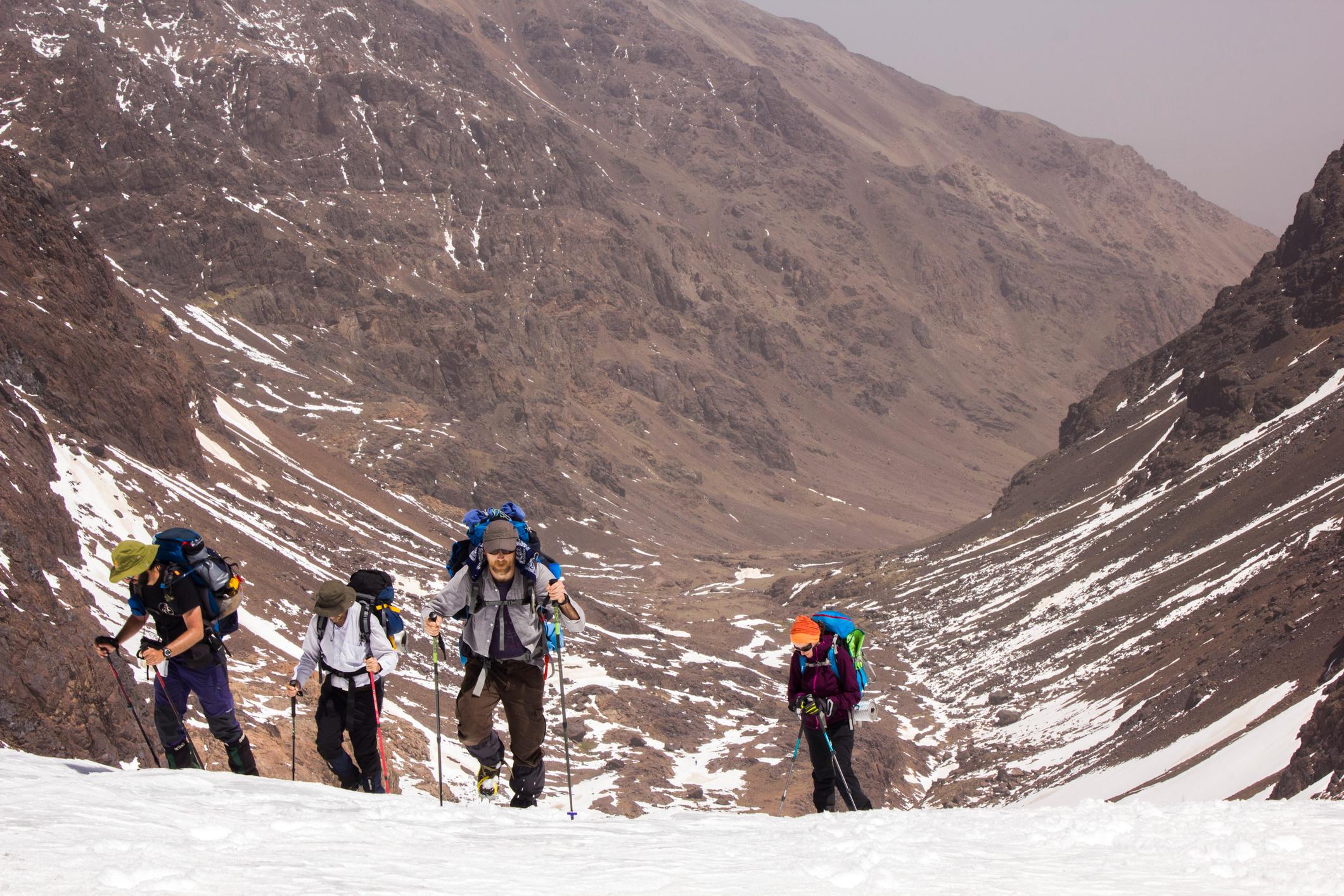 A group of hikers work their way up a snowy valley in the Atlas Mountains. Photo: Getty