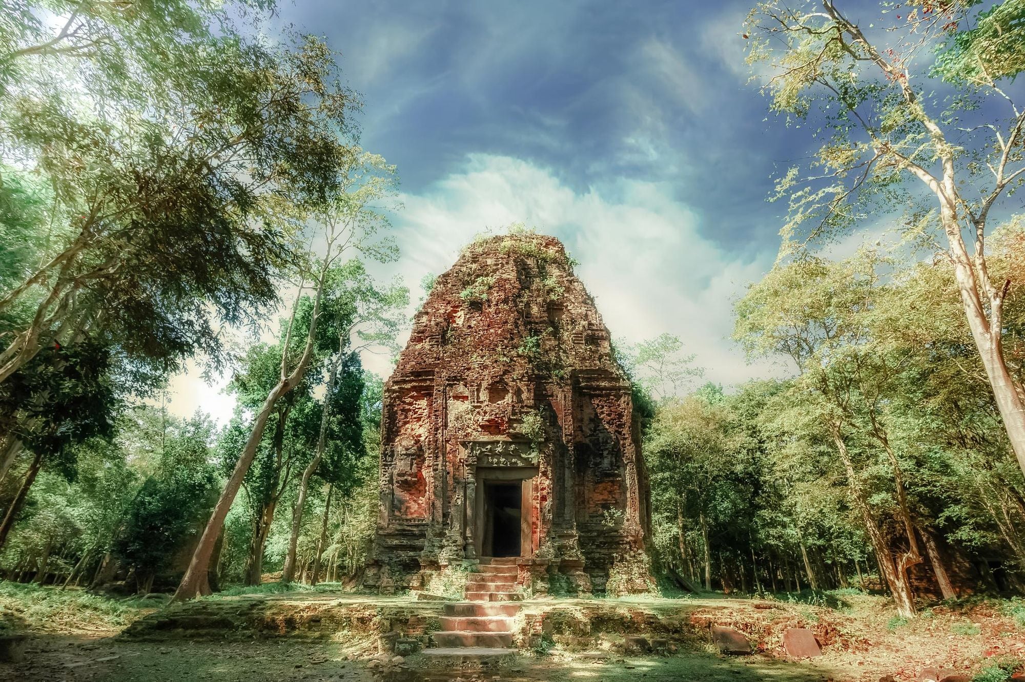 Sambor Prei Kuk temple ruins with the giant banyan trees besides, under blue sky. Photo: Getty